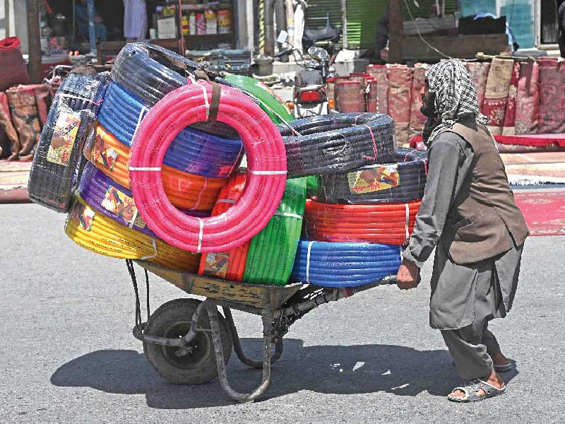 أفغاني يجرّ عربة محملة بالبضائع لبيعها في كابول أمس (أ ف ب)