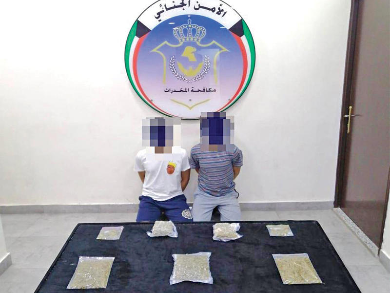 المتهمان وأمامهما المضبوطات