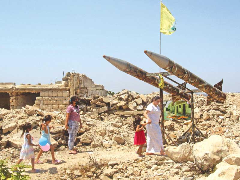 سيدة وأطفالها بمحيط أنقاض مركز اعتقال تابع لـ«جيش جنوب لبنان» المنحل عند الشريط الحدودي مع إسرائيل أمس الأولt(أ ف ب)