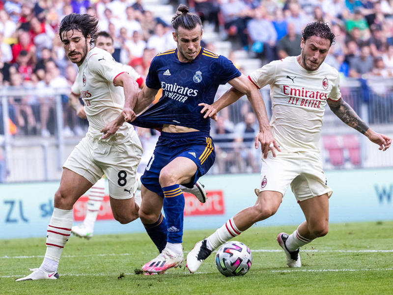  مهاجم الريال غاريث بيل يحاول المرور بين لاعبي ميلان ساندرو وكالابريا