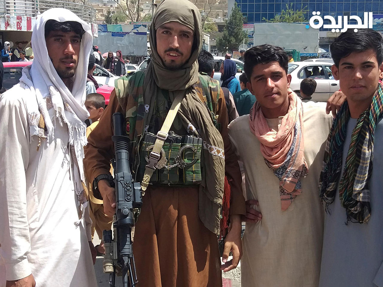 مقاتل من طالبان مع سكان محليين في مقاطعة بغلان (وكالة الصحافة الفرنسية)