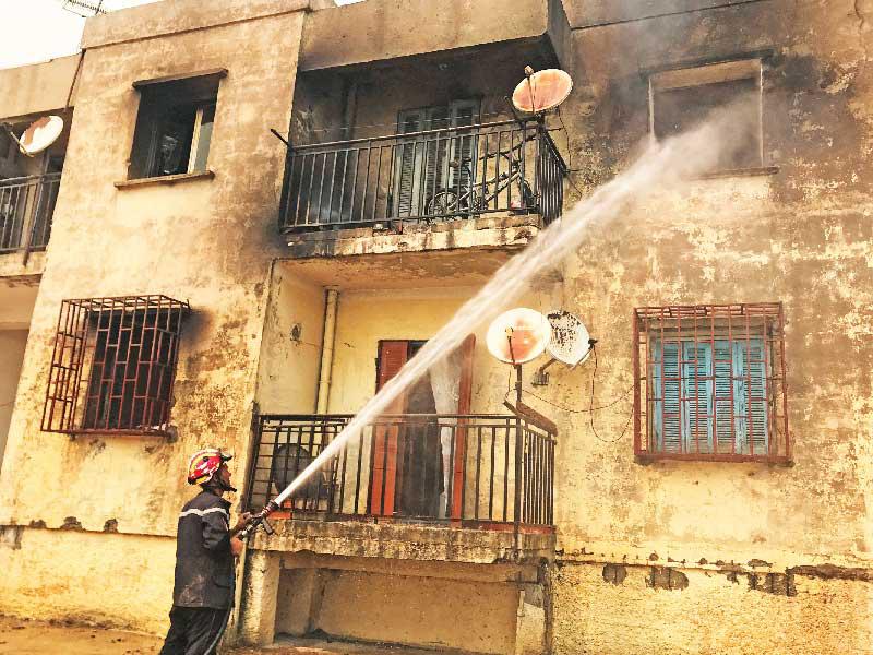 رجل إطفاء يخمد حريقاً في أحد المنازل بقرية عين الحمام الجزائرية            (رويترز)