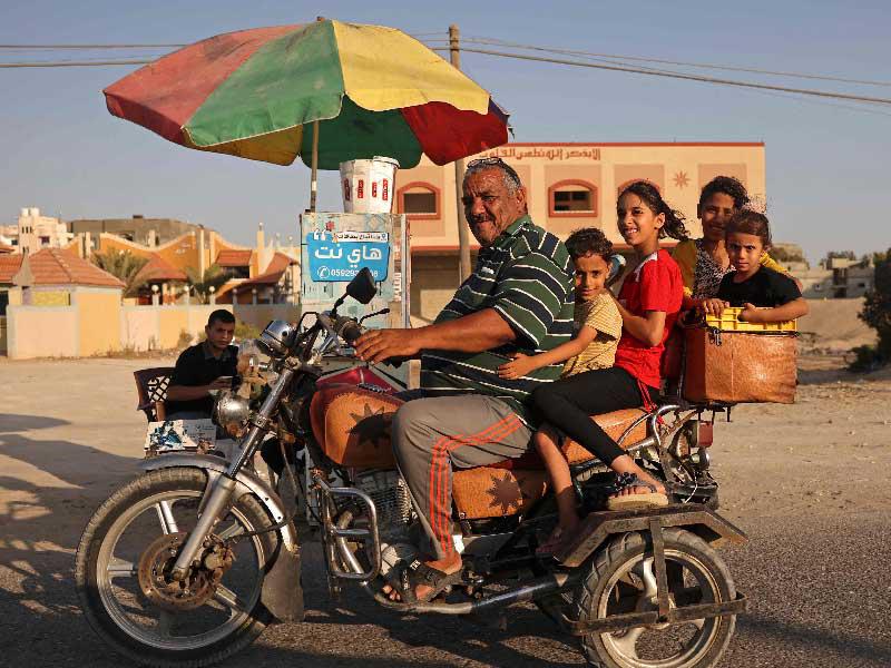 فلسطيني وهو يقود دراجة نارية مع اطفاله في رفح جنوب قطاع غزة