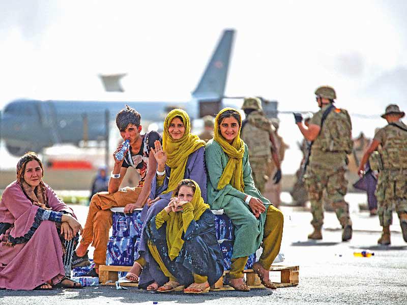 عائلة أفغانية تنتظر دورها ليتم نقلها من مطار كابول (أ ف ب)n