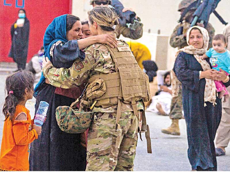 جندية أميركية تحتضن لاجئة أفغانية في مطار كابول (رويترز)n