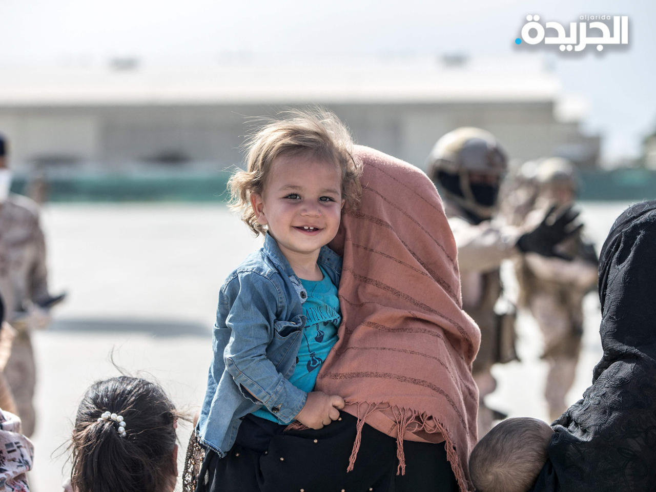 لاجئون أفغان في مطار كابول وسط حراسة قوات التحالف تمهيداً لإجلائهم