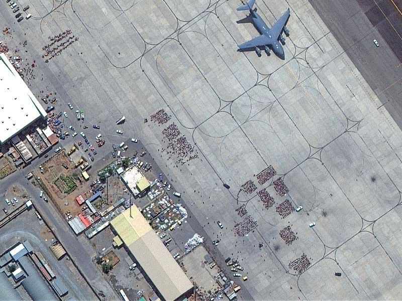 صورة جوية تظهر مجموعات بشرية تنتظر في مطار كابول الإجلاء (رويترز)