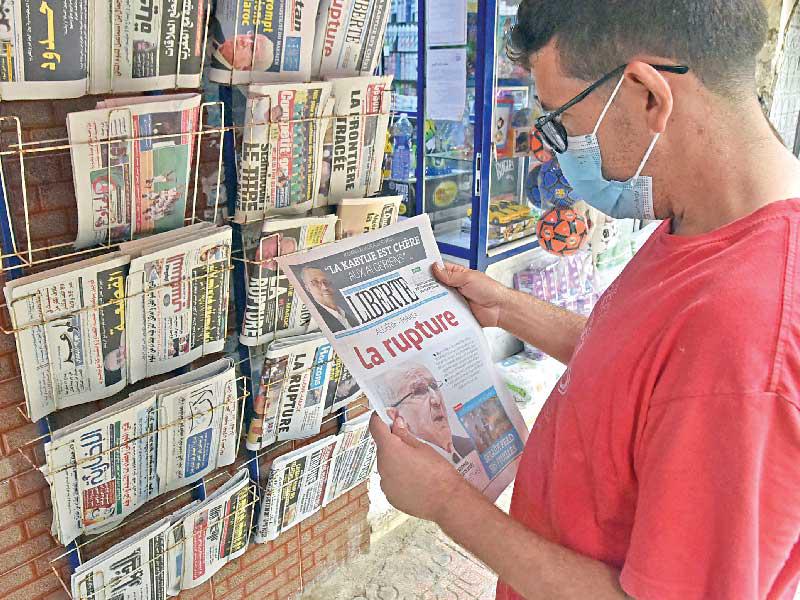 جزائري يطالع عناوين صحيفة صادرة أمس عنونت على صفحتها الأولى «الجزائر والمغرب... القطيعة»     (أ ف ب) 