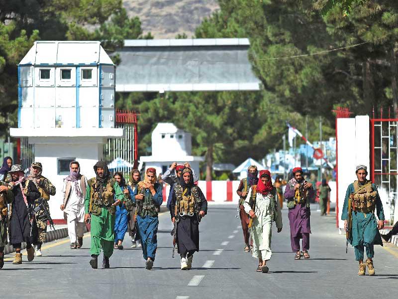 مسلحون من «طالبان» أمام أحد مداخل مطار كابول أمس   (أ ف ب)