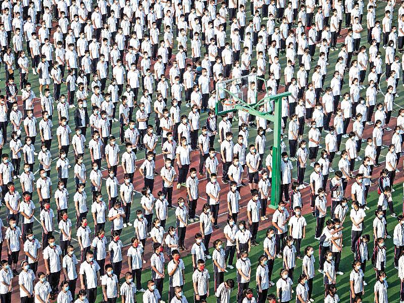 طلاب صينيون خلال أول يوم دراسي لهم في مقاطعة هوبي أمس (ا ف ب)