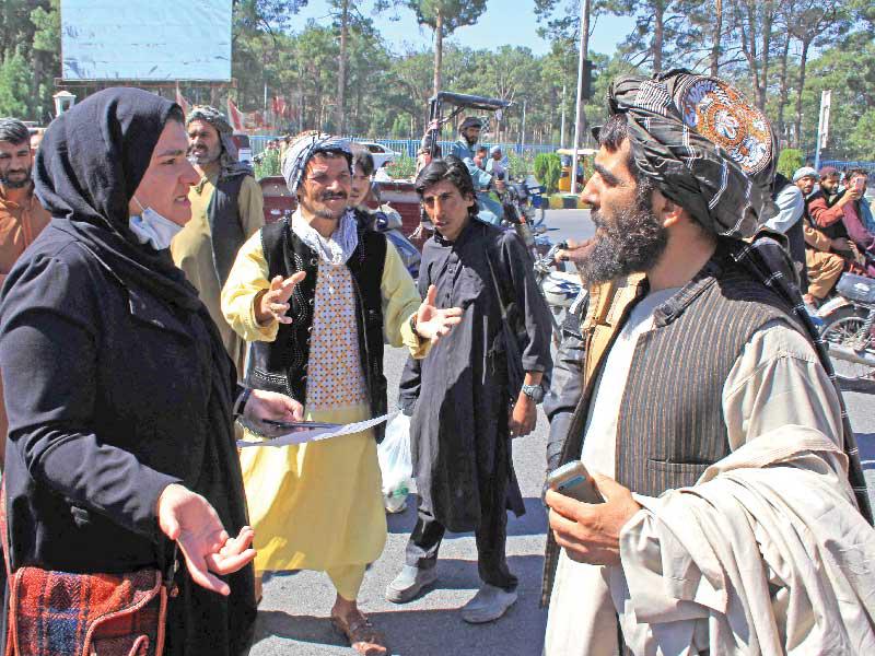 أفغانية تتحدّث لعنصر من «طالبان» خلال تظاهرة نسائية في هرات أمس      (أ ف ب)