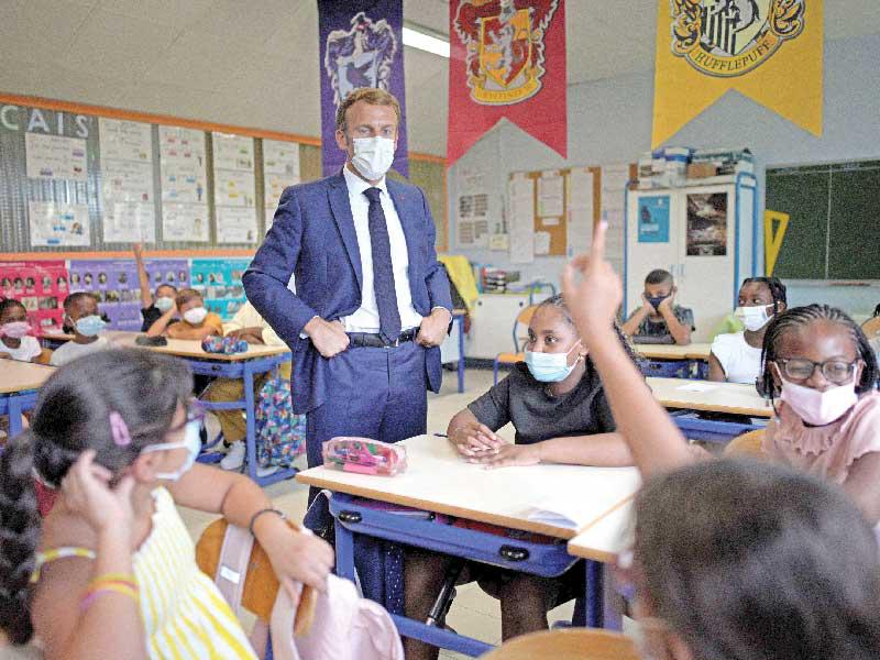 الرئيس الفرنسي إيمانويل ماكرون خلال زيارته لمدرسة في مرسيليا أمس (أ ف ب)