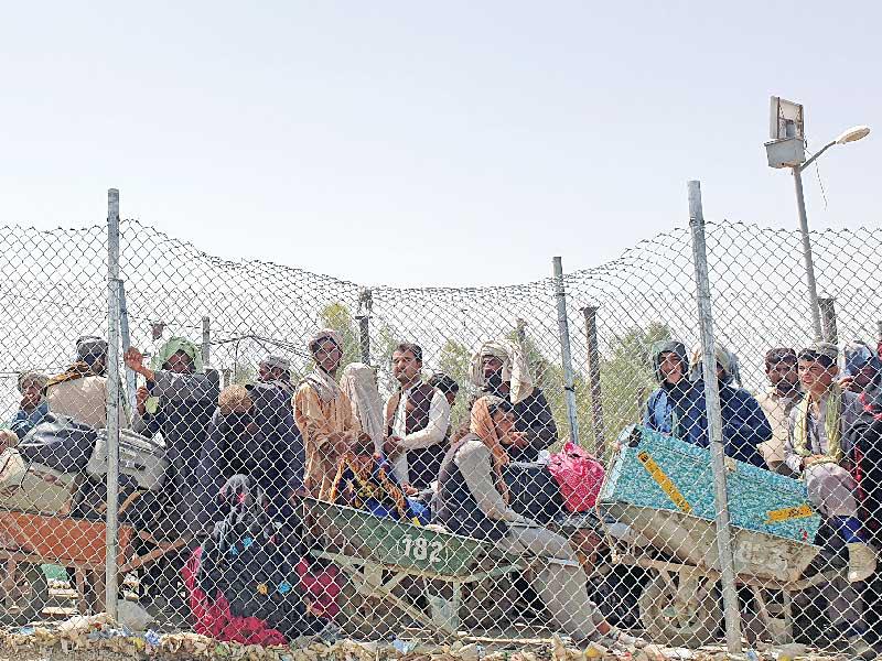أفغان ينتظرون السماح لهم بعبور الحدود إلى داخل باكستان أمس (رويترز)