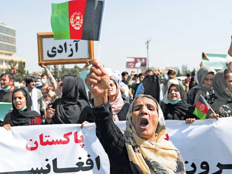 أفغانية تحمل علم بلادها وتتقدّم تظاهرة مناهضة لباكستان في كابول أمس     (رويترز)