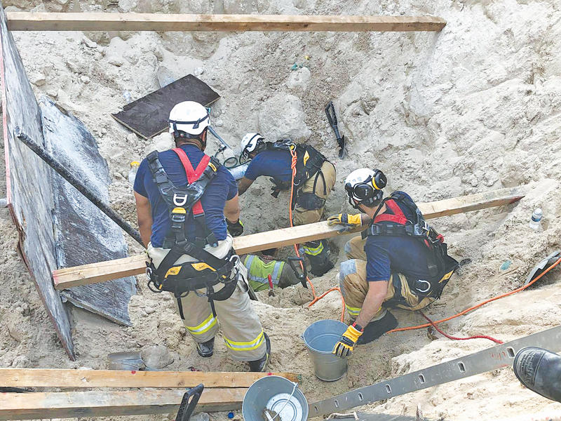 رجال الإطفاء خلال البحث عن المفقودين بالانهيار الرملي في مشروع المطار الجديد