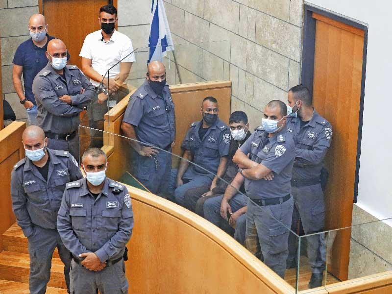 الأسير عارضة محاطاً بعناصر الأمن الإسرائيلي داخل المحكمة أمس الأول (أ ف ب)