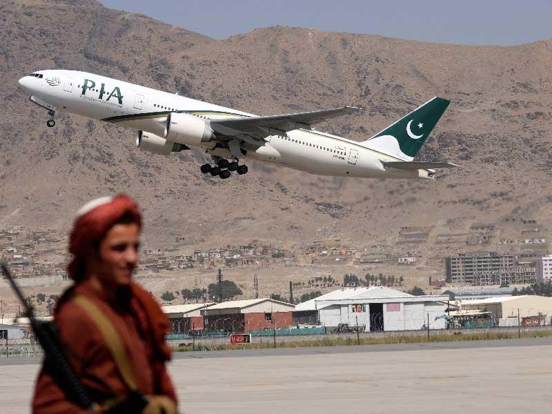 مسلّح من «طالبان» لحظة إقلاع طائرة ركاب باكستانية من مطار كابول أمس (أ ف ب)