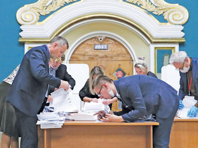 موظفون يفرزون أصوات الناخبين في موسكو أمس (رويترز)