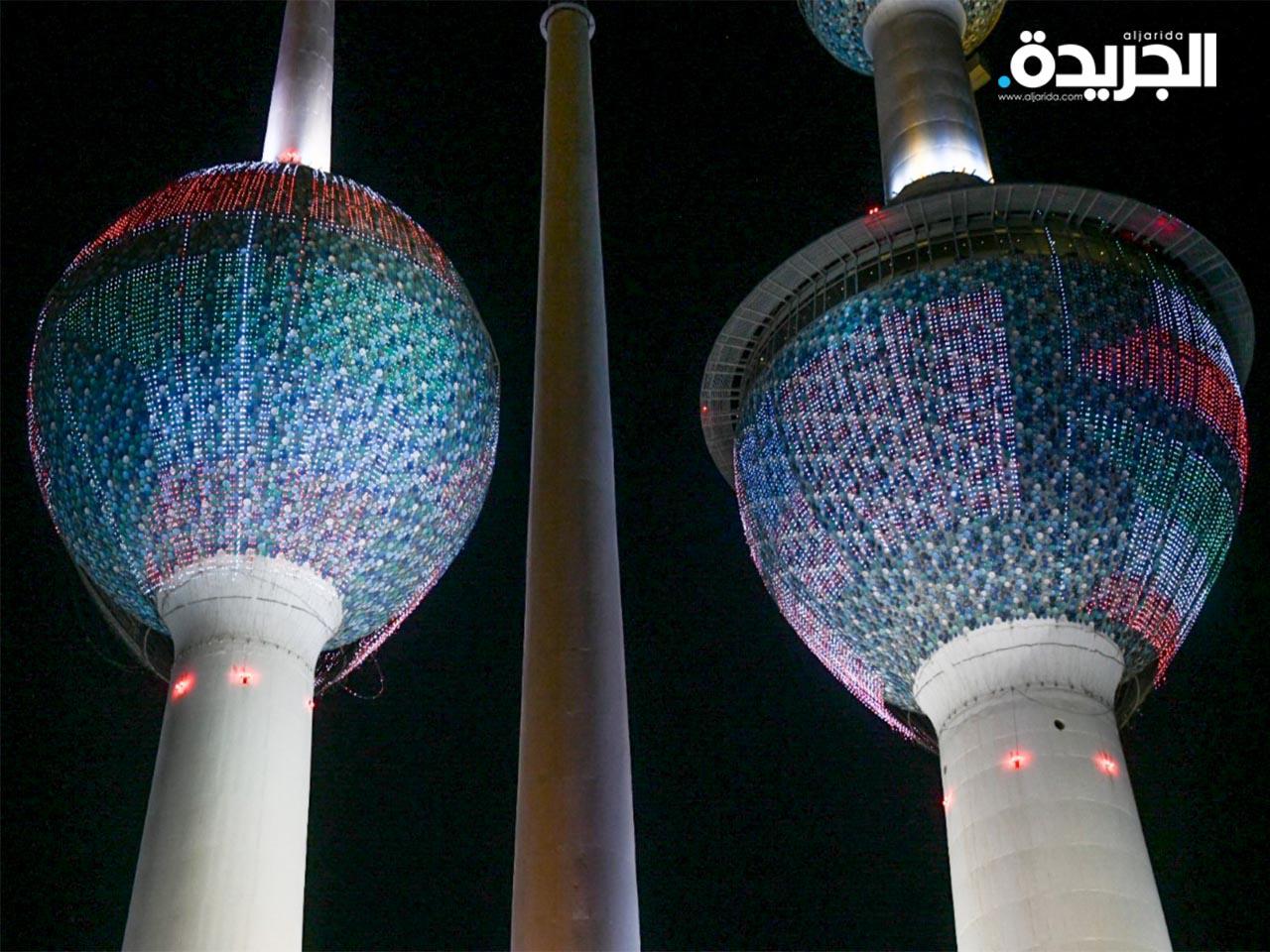 أبراج الكويت وعليها العلم الكويتي والعلم الأمريكي