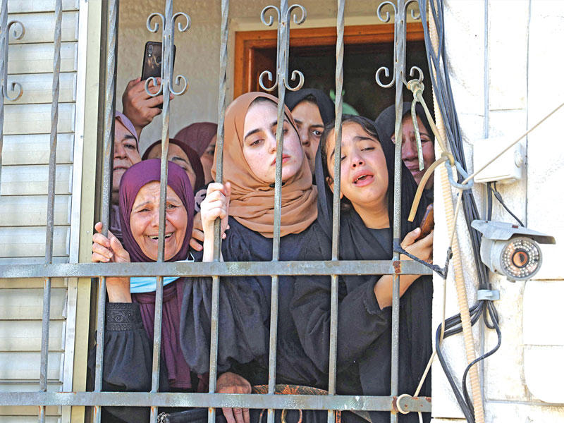 أقارب أحد الشبان الفلسطينيين الذين قتلوا برصاص إسرائيلي خلال تشييعه في الضفة أمس (ا ف ب)