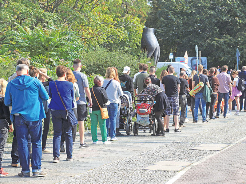 ألمان ينتظرون بالطابور للإدلاء بأصواتهم في الانتخابات ببرلين أمس (رويترز)