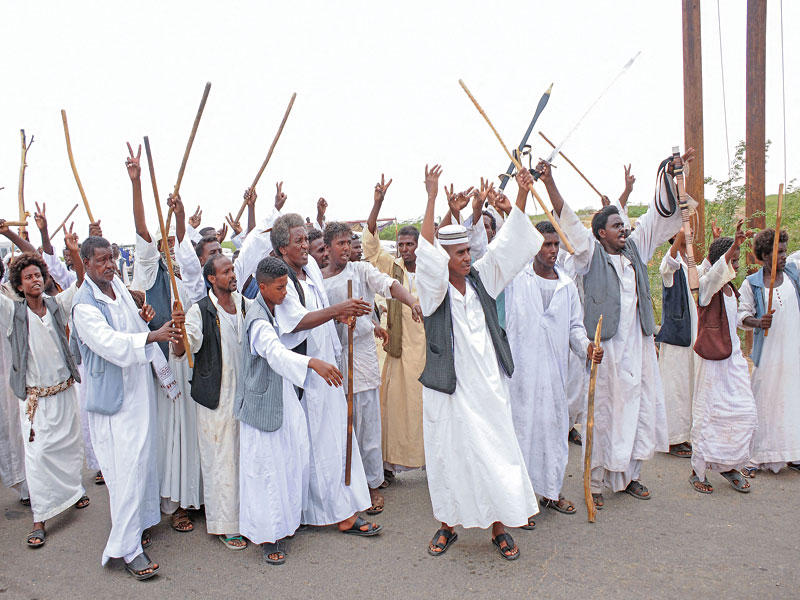 متظاهرون من المجموعة خلال استقبالهم الوفد الحكومي الذي أرسلته الخرطوم في بورتسودان            (أ ف ب)
