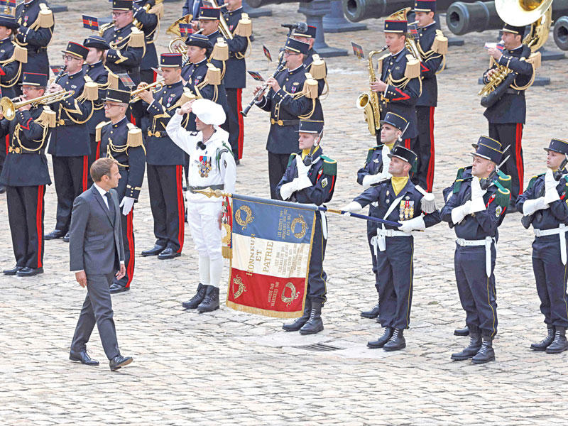 الرئيس الفرنسي إيمانويل ماكرون يستعرض الأسبوع الماضي حرس الشرف في ثكنة «اوتيل ديزينفاليد» خلال مراسم تشييع جندي قتل في مالي       (أ ف ب ) 