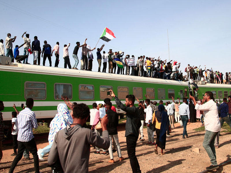 محتجون قادمون من مدينة ودمدني على متن قطار للمشاركة في تظاهرة داعمة للحكم المدني (أ ف ب) 