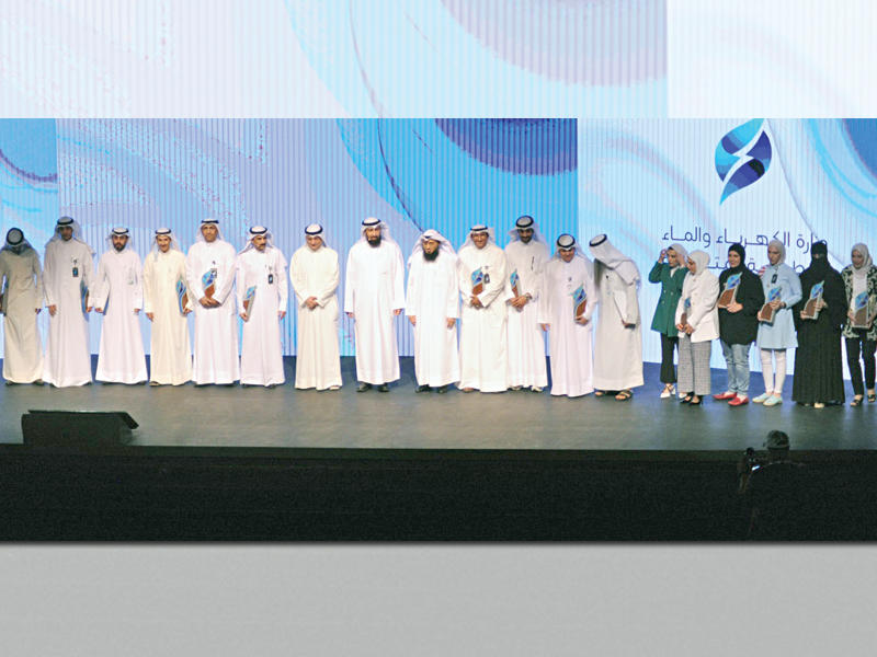 وزير الكهرباء والماء والطاقة المتجددة د. مشعان العتيبي متوسطاً المشاركين في مشروع العدادات الذكية 