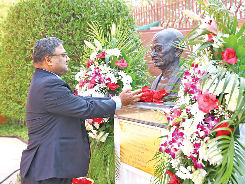 السفير جورج يضع الزهور على تمثال غاندي