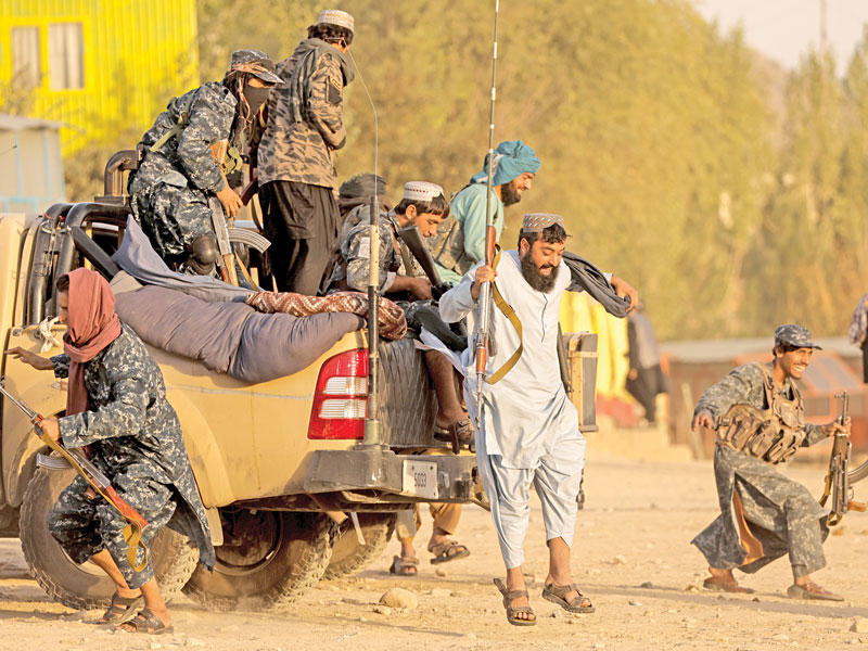 مسلّحون من «طالبان» ينزلون من آليتهم للاستمتاع بيوم عطلة نادر في المنتزه الواقع بمنطقة خزان قرغة في كابول أمس الأولt (رويترز)