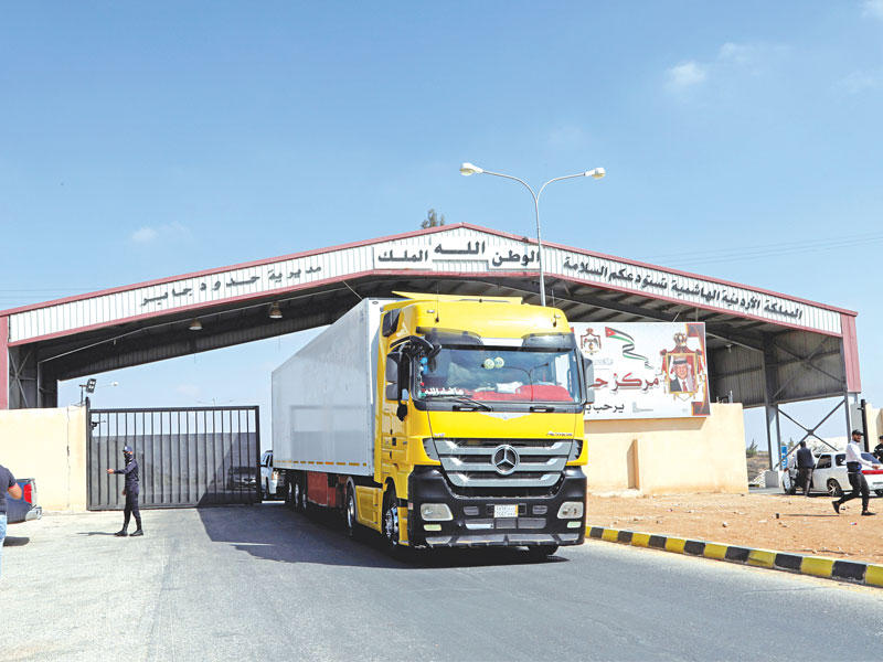 شاحنات تمر عبر معبر جابر بين سورية والأردن قبل أيام (رويترز)