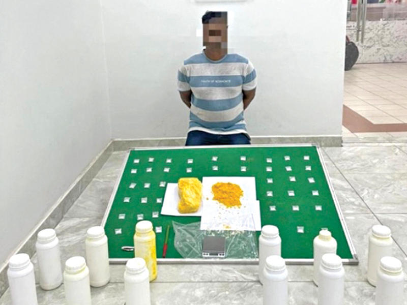 المتهم وأمامه المضبوطات 