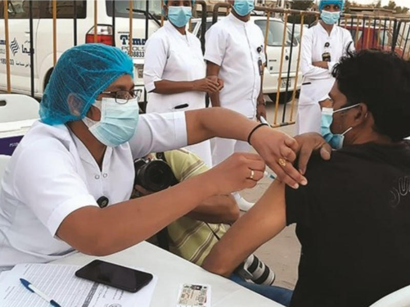 تطعيم أحد العمال في منطقة بنيد القار