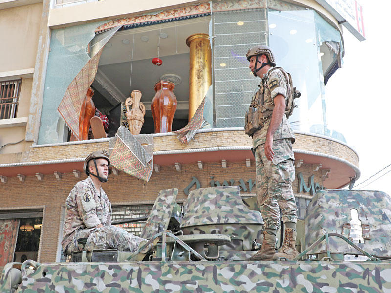 جنديان على آلية عسكرية في موقع الاشتباكات أمس