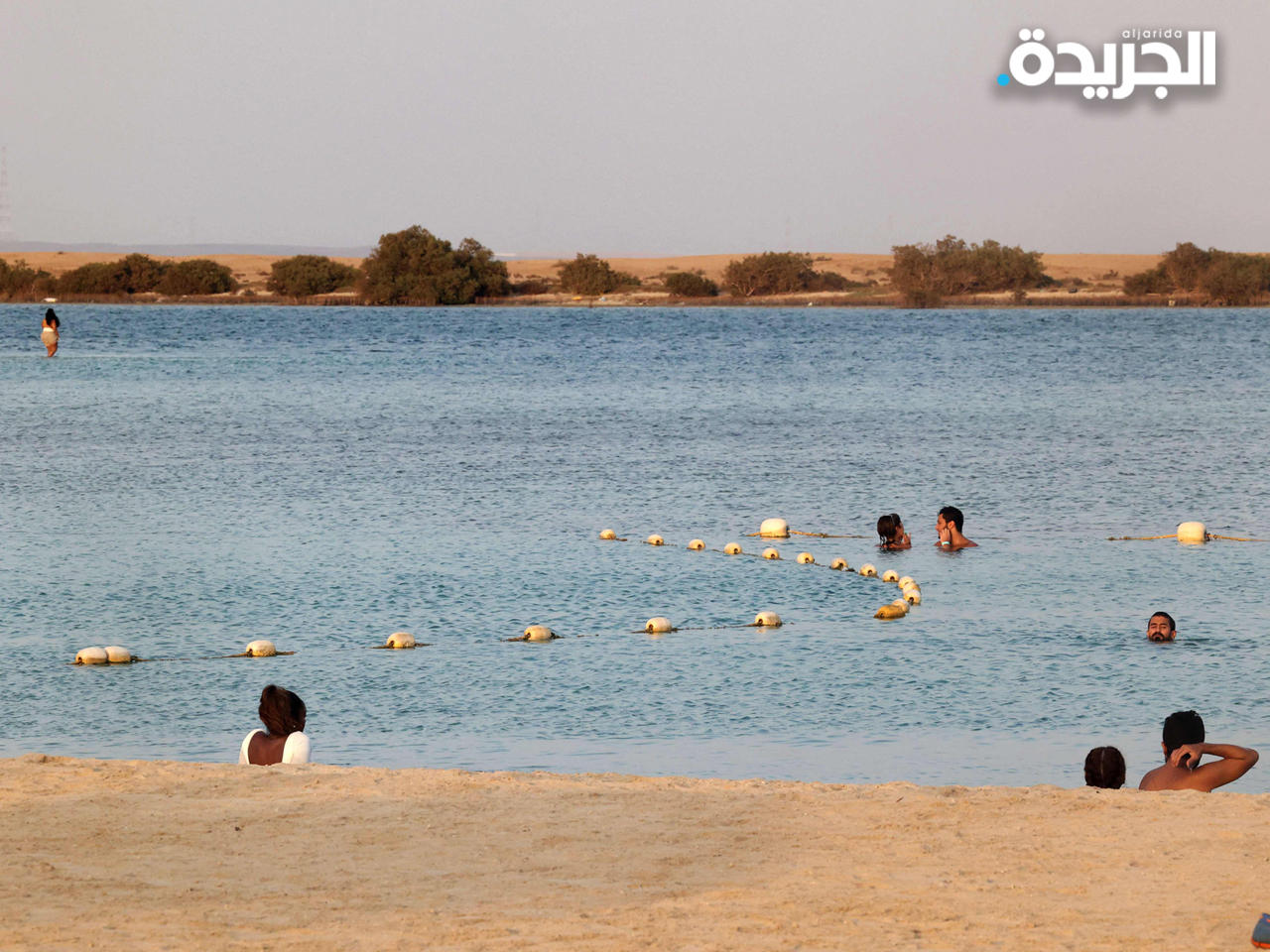 سياح يستلقون على أحد الشواطئ في السعودية