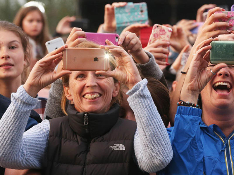 مجموعة من الجمهور يوثقون حدثاً باستخدام هواتفهم الذكية