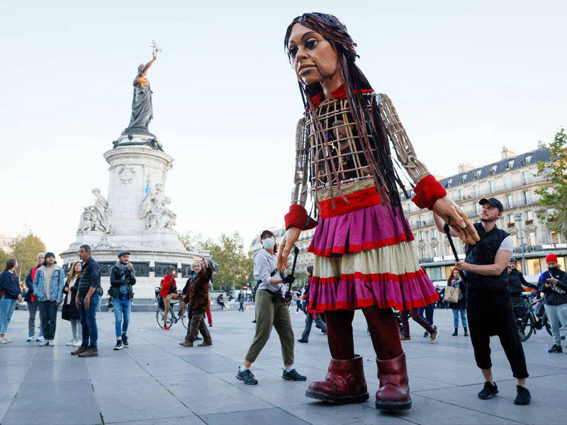 الدمية العملاقة «أمل الصغيرة» التي تجسد طفلة سورية لاجئة بساحة الجمهورية في باريس أمس t(أ ف ب )  