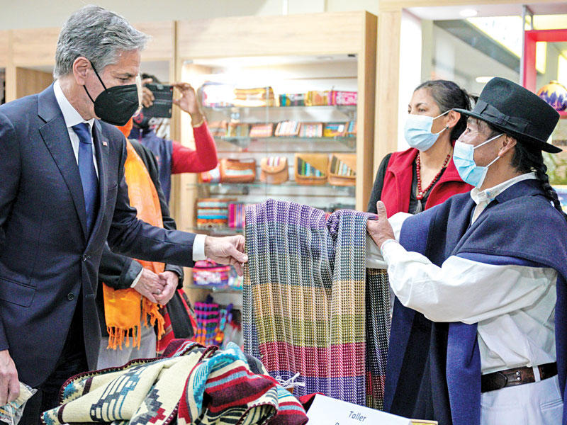 وزير الخارجية الأميركي أنتوني بلينكن يتفقد بضائع في سوق للسكان الأصليين بالإكوادورt (رويترز)