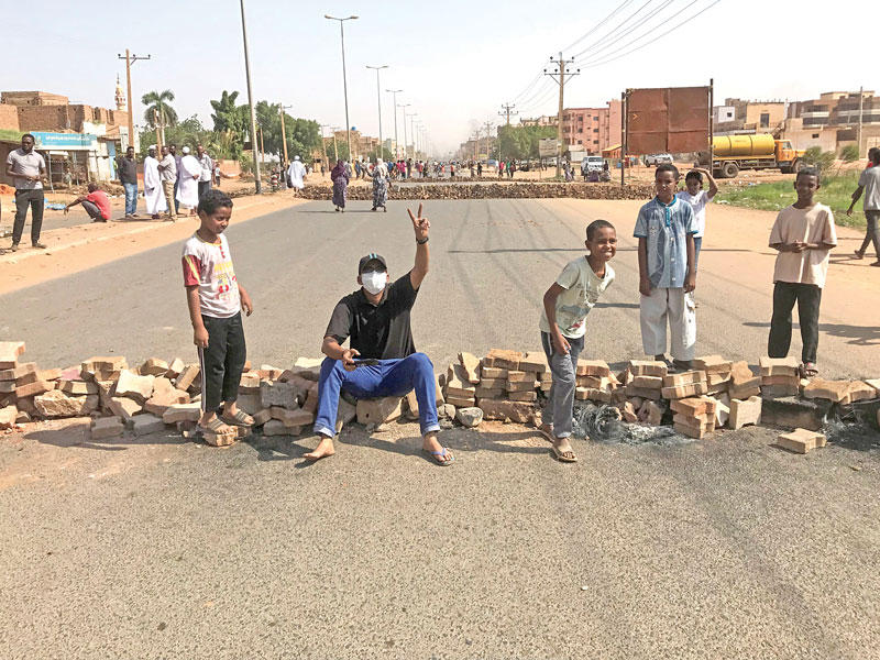 محتجون يغلقون أحد الشوارع في الخرطوم أمس t(رويترز)