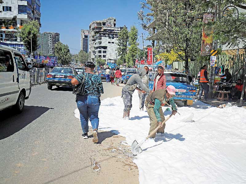 إثيوبيون ينظفون شارعاً في حي ميجيناجنا بأديس أبابا أمس الأول           (رويترز)