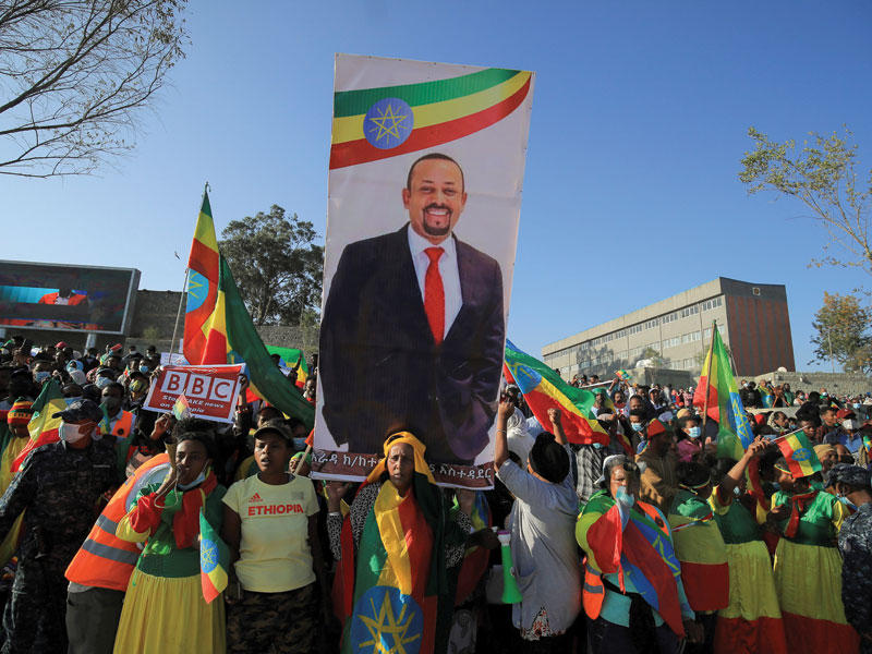 متظاهرون يحملون صورة لآبي أحمد أمس في أديس ابابا (رويترز)