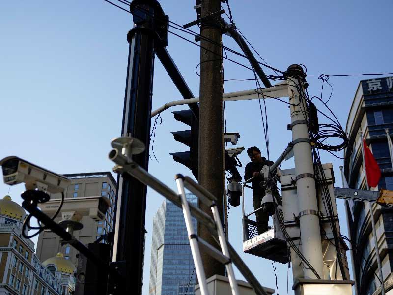 موظف صيني يتفقد كاميرات المراقبة في أحد شوارع شانغهاي أمس الأول t(رويترز)