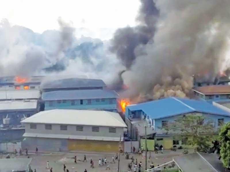 أبنية تلتهمها النيران خلال أعمال الشغب بالحي الصيني في عاصمة جزر سليمان أمس (رويترز)