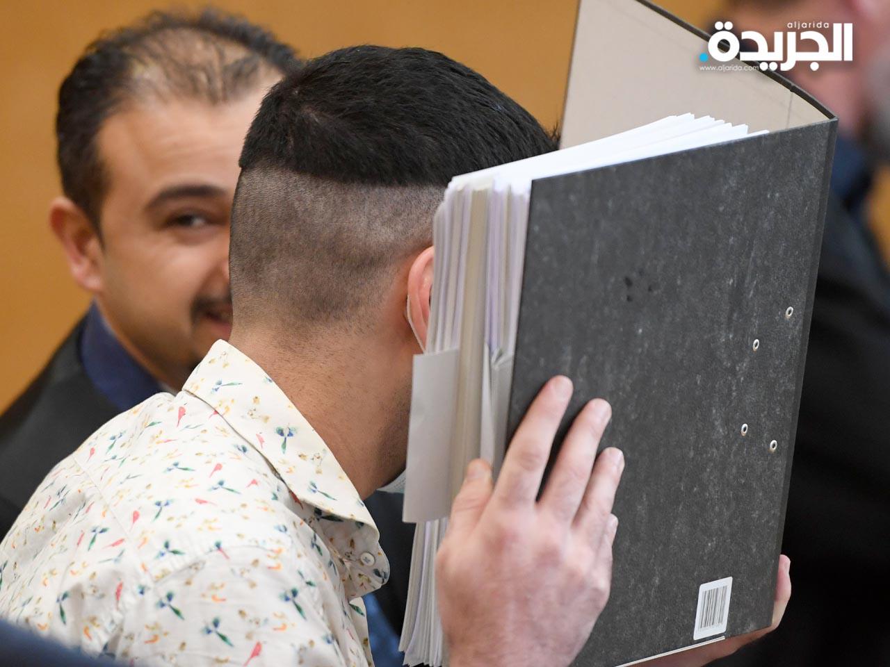 العراقي طه الجميلي يخفي وجهه قبل بدء محاكمته في فرانكفورت، ألمانيا