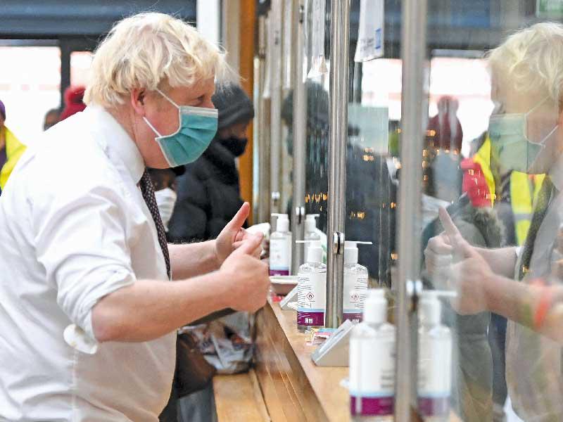 رئيس وزراء بريطانيا بوريس جونسون يزور أحد مراكز التطعيم في لندن أمس       (أ ف ب)