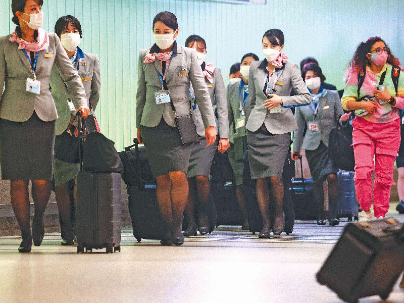 مضيفات يضعن كمامات لدى وصولهن إلى مطار لوس أنجلس الأميركي (أ ف ب)