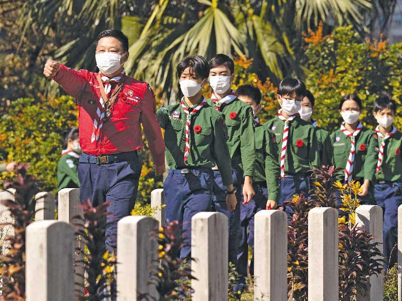 كشافة خلال حفل نظمته كندا لتكريم ضحايا الحرب العالمية الثانية بمقبرة الكومنولث في هونغ كونغ أمس (أ ف ب)