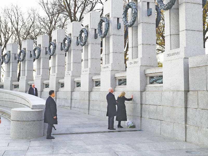 بايدن وزوجته جيل عند نصب ضحايا الحرب العالمية الثانية أمسt (رويترز)