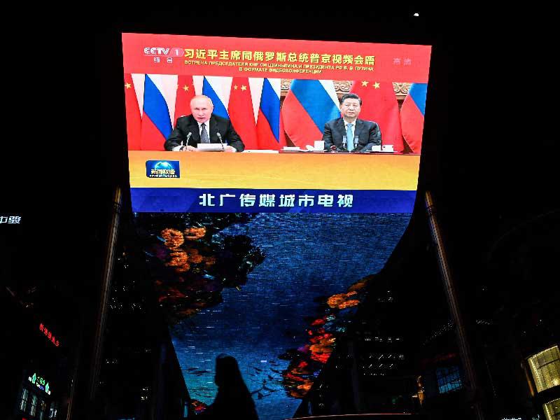 شاشة عملاقة في بكين تبث الاتصال بين شي جينبينغ وبوتين (أ ف ب) 